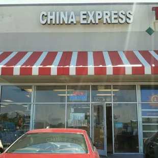 a red car parked in front of a store