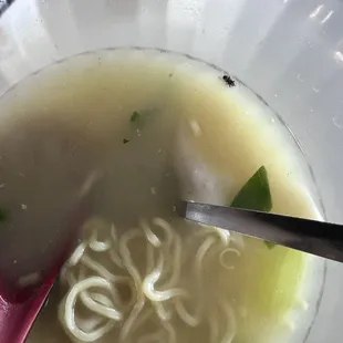 a bowl of soup with noodles and a spoon