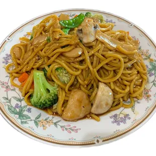 a plate of noodles with chicken and broccoli