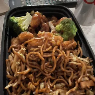 a tray of noodles and broccoli