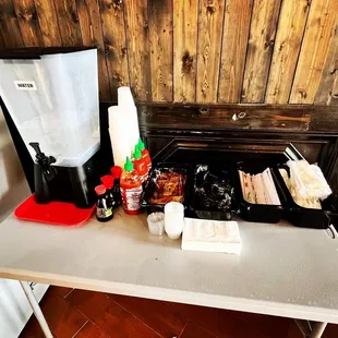a table with a coffee maker and condiments