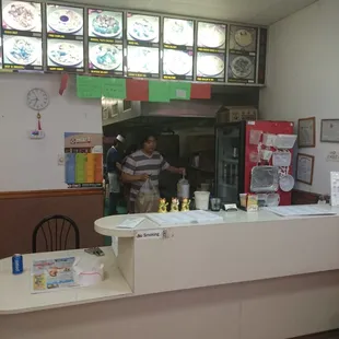 a man standing at a counter in a restaurant