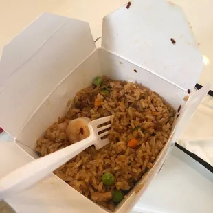 a take out box of rice with a fork