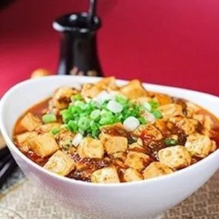 a bowl of tofu and chopsticks