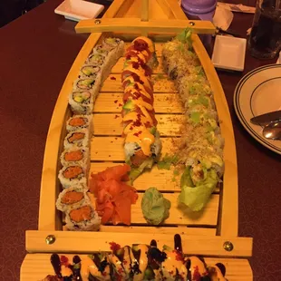 a long wooden boat with sushi on it