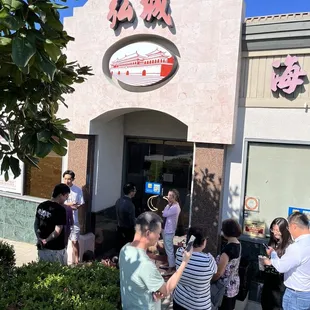 a group of people outside a chinese restaurant