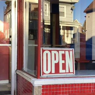 open sign in window of store