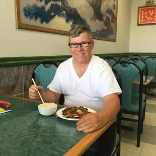 a man sitting at a table with a plate of food