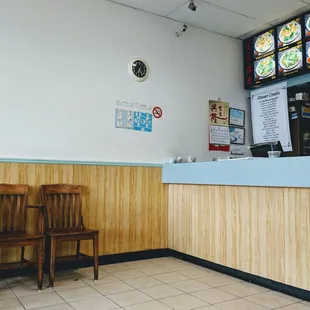 a restaurant counter with two wooden chairs