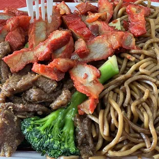 a plate of noodles with meat and broccoli