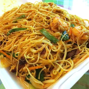 a plate of noodles with shrimp and vegetables