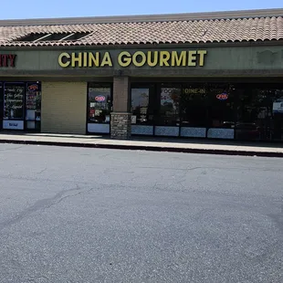 an empty street in front of a chinese gourmet store