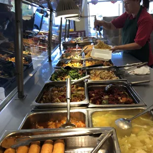 a woman serving food at a buffet