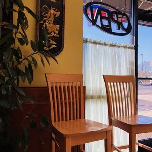 two wooden chairs in front of a window