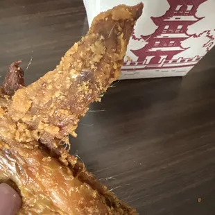 a hand holding a half eaten donut