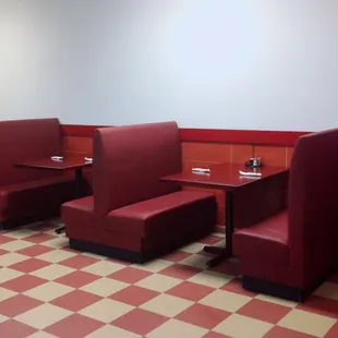 a restaurant with red booths and a fish tank