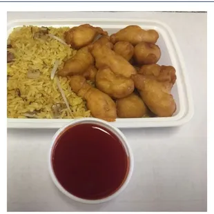 a plate of fried chicken, rice, and sauce