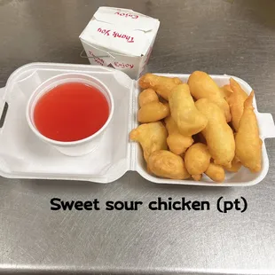 a container of sweet sour chicken and a cup of tea
