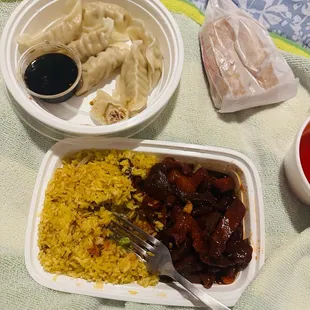 a plate of dumplings, rice, and sauce