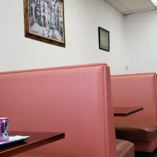 a pink booth with a tray of food on the table
