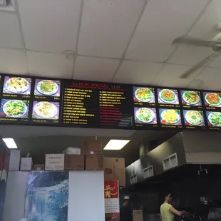 Menu board. The lady in the background cooking, I believe she's the owner.