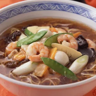 a bowl of soup with shrimp and vegetables