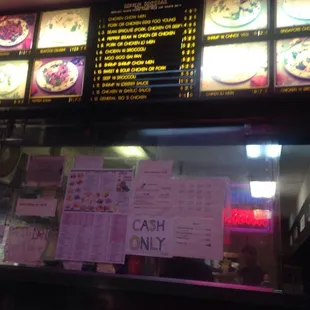 Menu board and assorted signs on the bulletproof glass