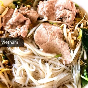 a bowl of noodles with meat and vegetables