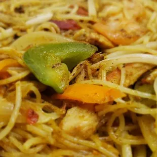 a plate of noodles with shrimp and vegetables