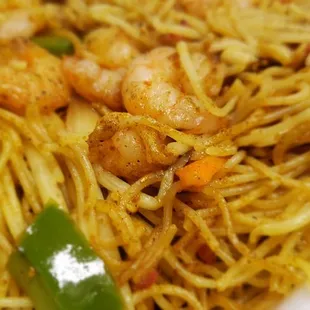 a plate of noodles with shrimp and vegetables