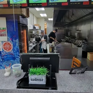 a restaurant counter with menus on the wall