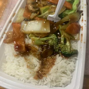 a plastic container with rice, broccoli, and meat