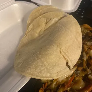 a tortilla in a styrofoam container