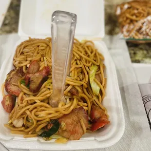 a plate of noodles and chopsticks