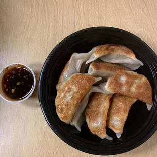 a plate of dumplings with dipping sauce