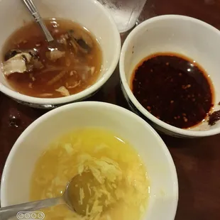 three bowls of soup and a glass of water