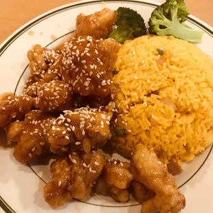 a plate of chinese food with rice and broccoli