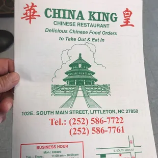 a hand holding a menu for a restaurant