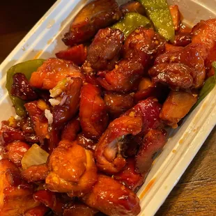 chicken and vegetables in sauce in a styrofoam container