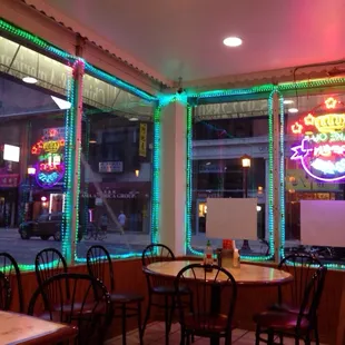 a restaurant with neon signs in the window