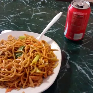 a plate of noodles and a can of soda