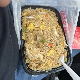 a plastic container filled with fried rice