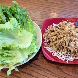 a plate of lettuce and a plate of noodles