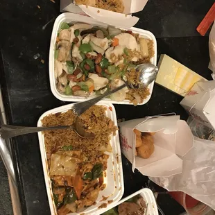 three takeout containers of food on a table