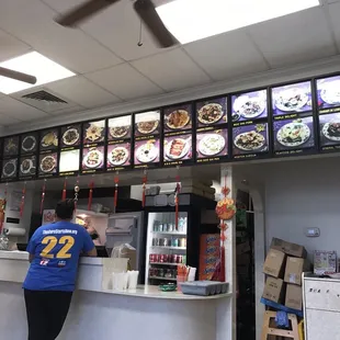 two people standing in front of a restaurant counter