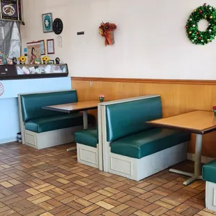a booth with green booths and a wreath on the wall