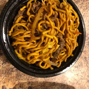 a bowl of noodles and a plate of meat