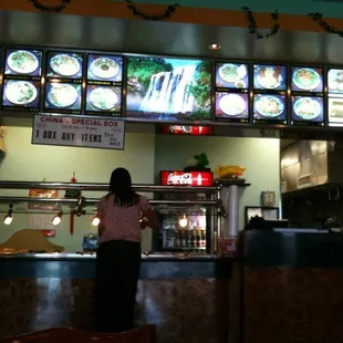 a woman standing in front of a restaurant counter