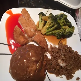a plate of food with meat, rice, broccoli and sauce