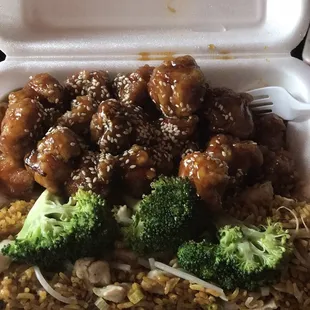 a takeout container with rice and broccoli